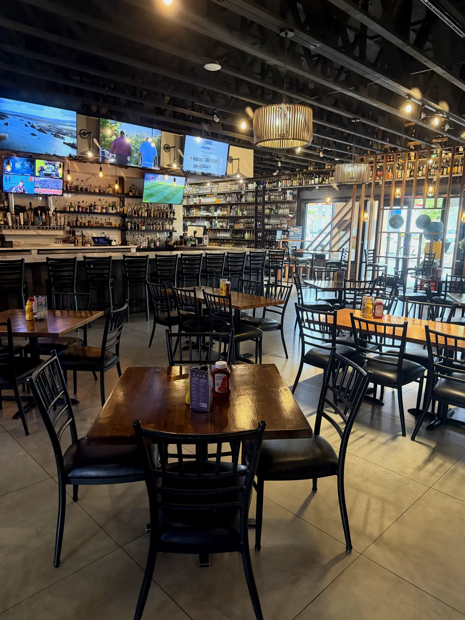 The KnB bar with a wall of TVs, taps and backlit bottles