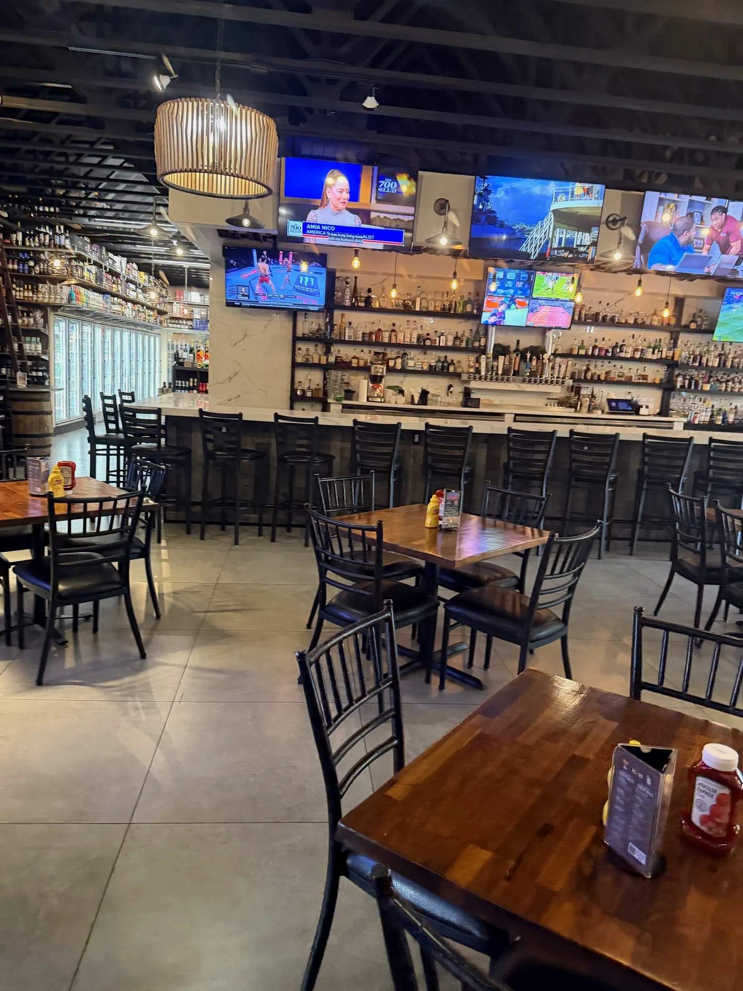 Long bar with high-top seats and TVs